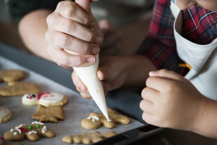 Vegan and Vegetarian-Friendly Holiday Baking Recipes. Boy making gingerbread cookies with his mum